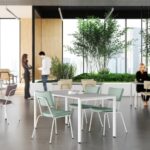 Ruime en lichte onderwijskantine met flexibele tafels, comfortabele stoelen en geïntegreerde groenvoorziening voor informele ontmoetingen.