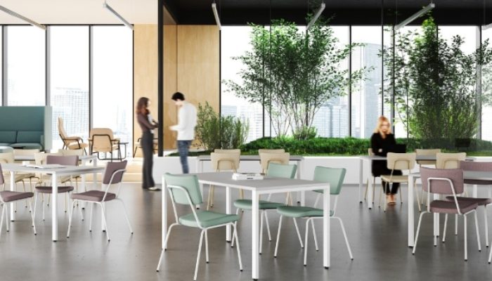Ruime en lichte onderwijskantine met flexibele tafels, comfortabele stoelen en geïntegreerde groenvoorziening voor informele ontmoetingen.